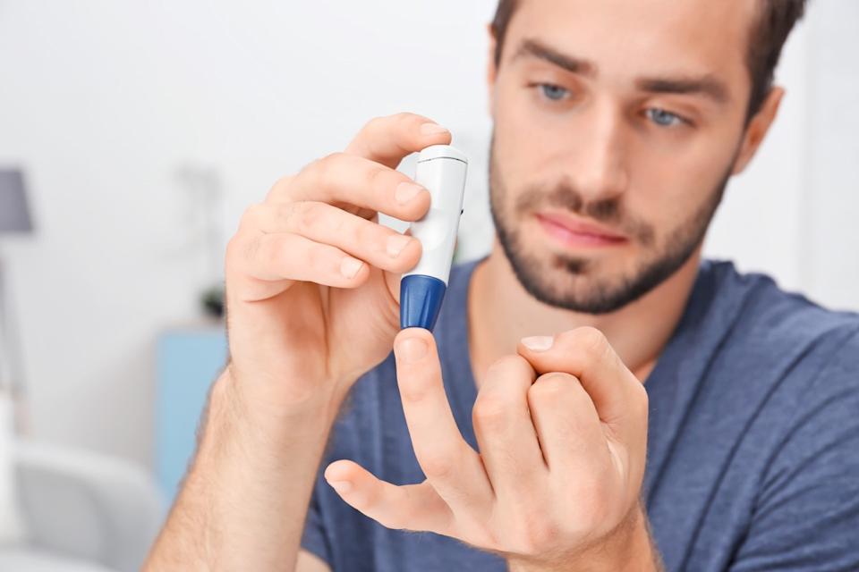 Man with diabetes pricking finger