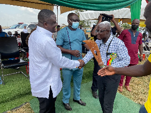 Collins Adomako-Mensah presenting the prize to the overrall best farmer