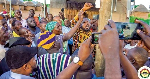 Alhaji Mohammed Habib Iddrisu (arrowed) MP for Tolon being assisted by some community leaders to switch on the light