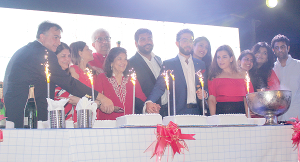 Owners and management of Melcom cutting a cake at the event to signify its new brand identity