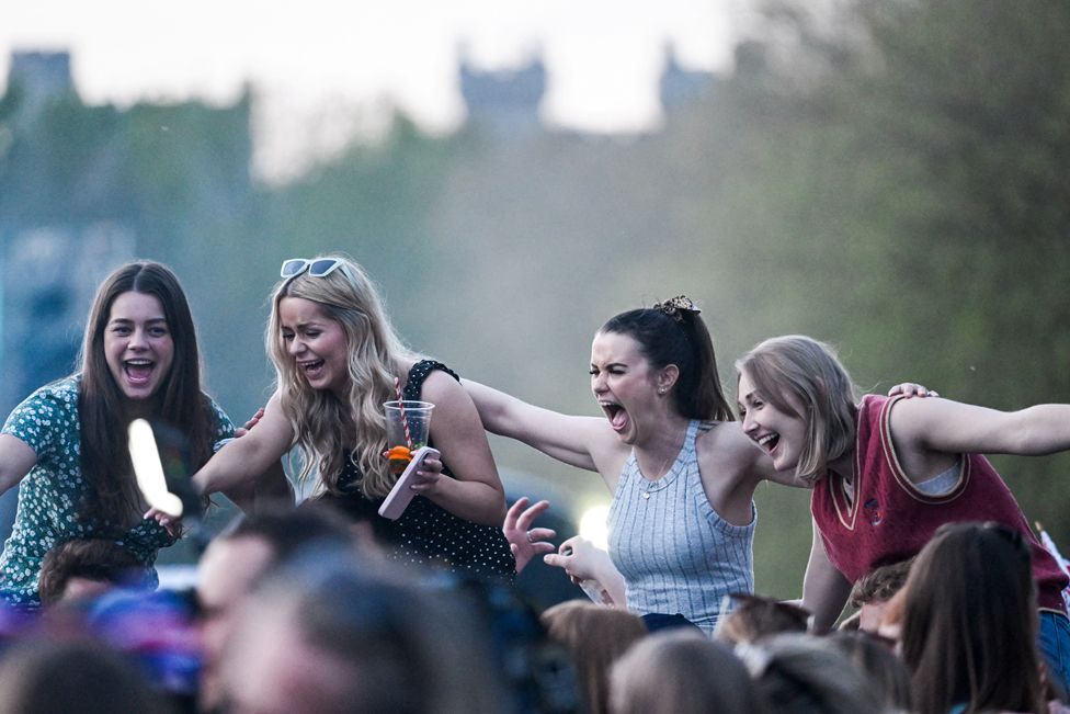 People react as they watch a screening of the concert marking Britain's King Charles' coronation, near Windsor Castle, Windsor, Britain May 7, 2023