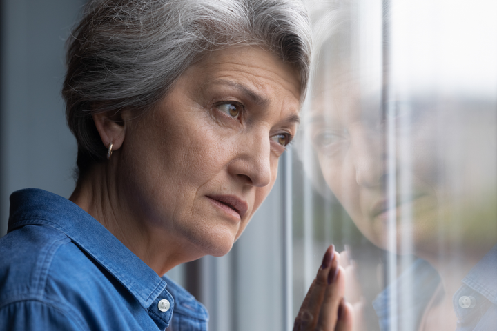 Closeup of Senior Woman Looking Longingly Out of Her Window